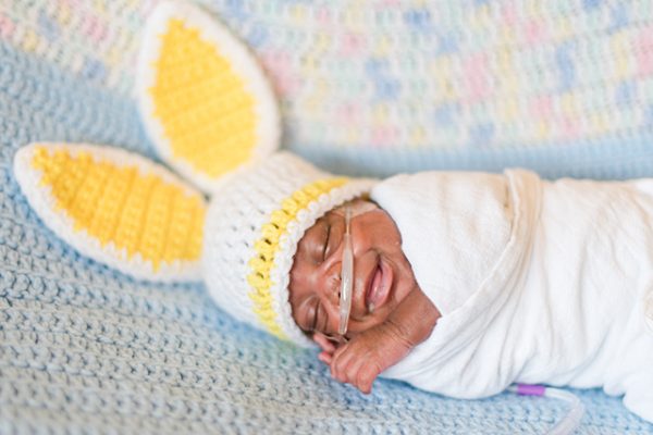Baby in the NICU wears crochet bunny ears.