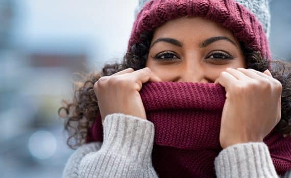 Woman with scarf over face; follow these healthy winter tips.