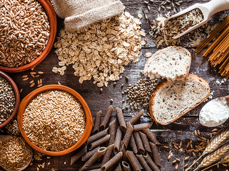 Good and bad carbs lying on table like brown rice, bread and oatmeal.