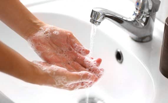 Washing hands in a sink; handwashing wards away virus