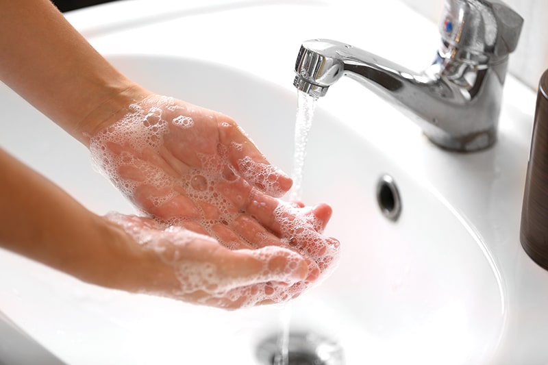 Washing hands in a sink; handwashing wards away virus