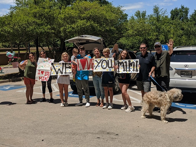 Friends and family of barbara "mimi" winn supporting her with signs and smiles