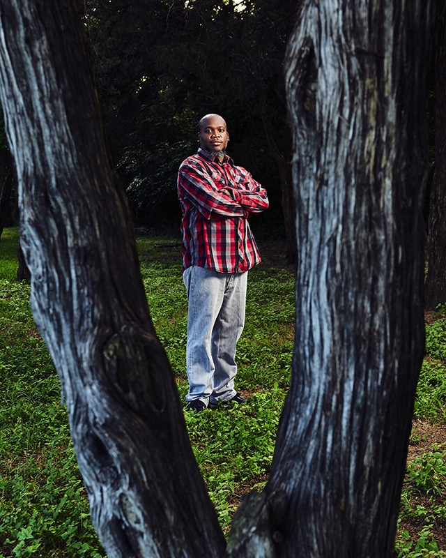 Methodist Dallas patient Marcus Hawkins standing between trees and looking to camera, after experimental drug allows him to fight off COVID-19