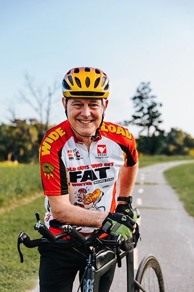 Profession Bob Kaiser looks at the camera and smiles while cycling