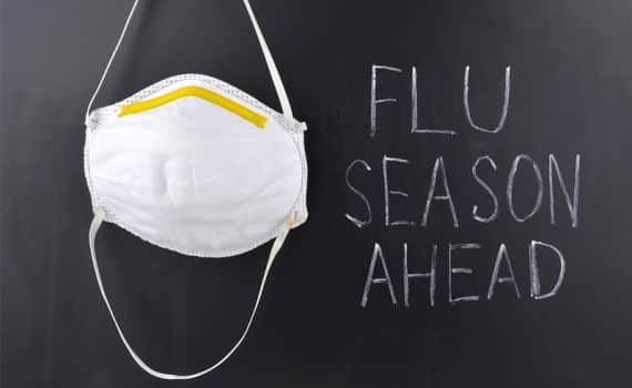 chalkboard that says "flu season ahead" and a hanging face mask