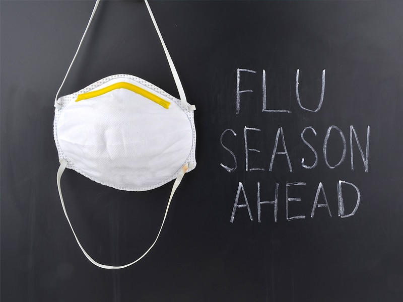 chalkboard that says "flu season ahead" and a hanging face mask