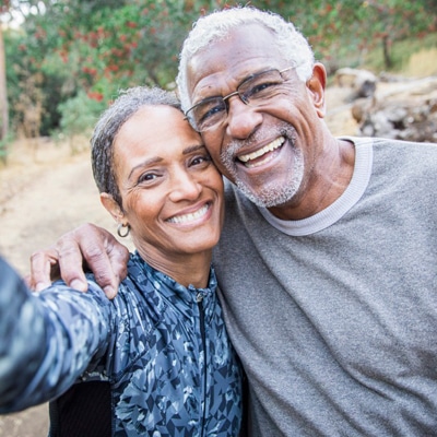 Older man and woman smile while taking selfie