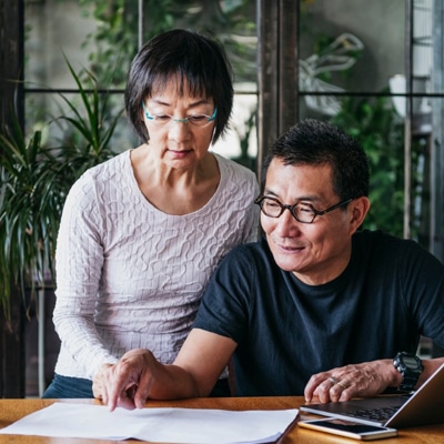 Older man and woman looking at paperwork on a table