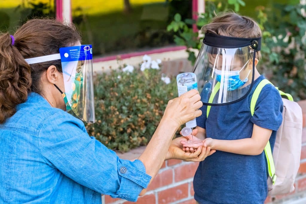 Woman and young boy with face mask and face shield on