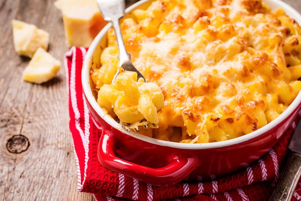 Red casserole dish with mac and cheese, a soul food classic