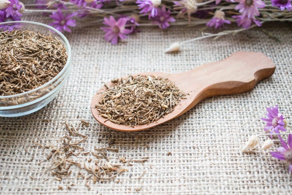 Valerian root in a bowl and on a wooden spoon, which can be used for sleep aids