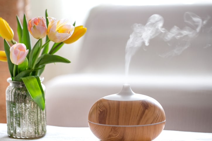A wooden air diffuser with a vase and flowers, a low stress scene