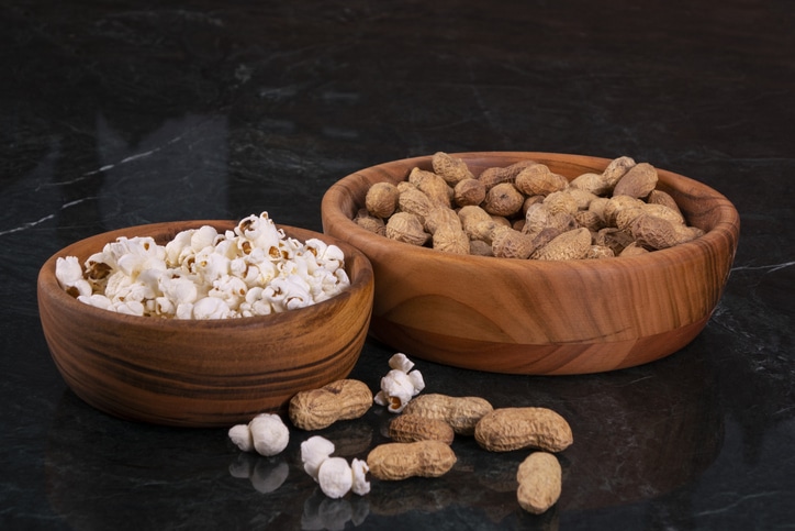 Peanuts and popcorn in wooden bowls