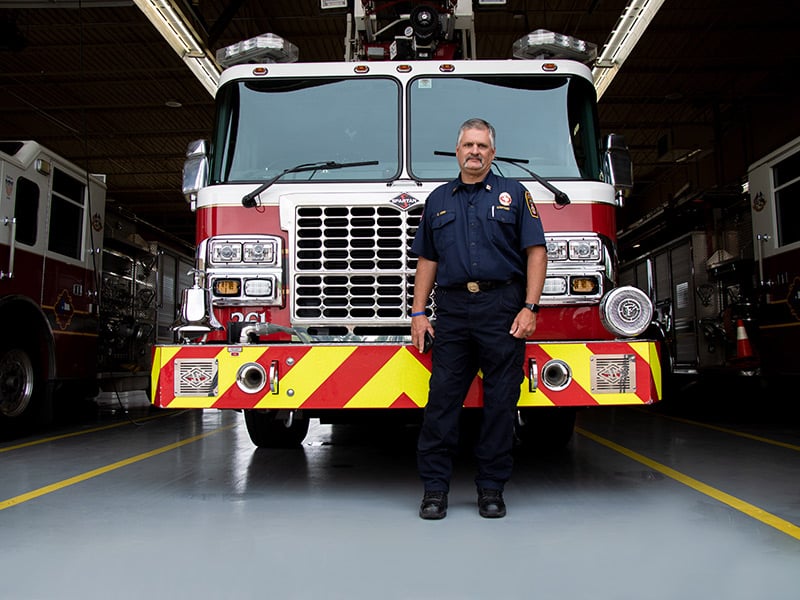 DeSoto firefighter Craig Kirk standing in front of a fire truck