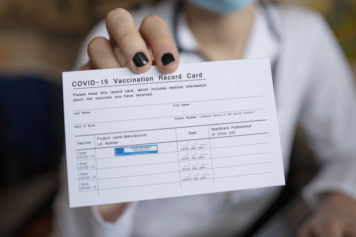 Someone holding their COVID-19 vaccination card