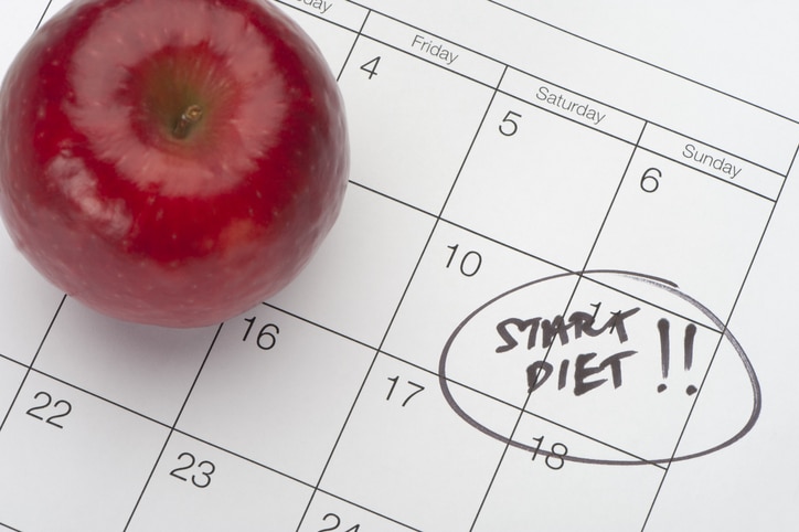 A red apple next to a calendar with the words "start diet!!" circled