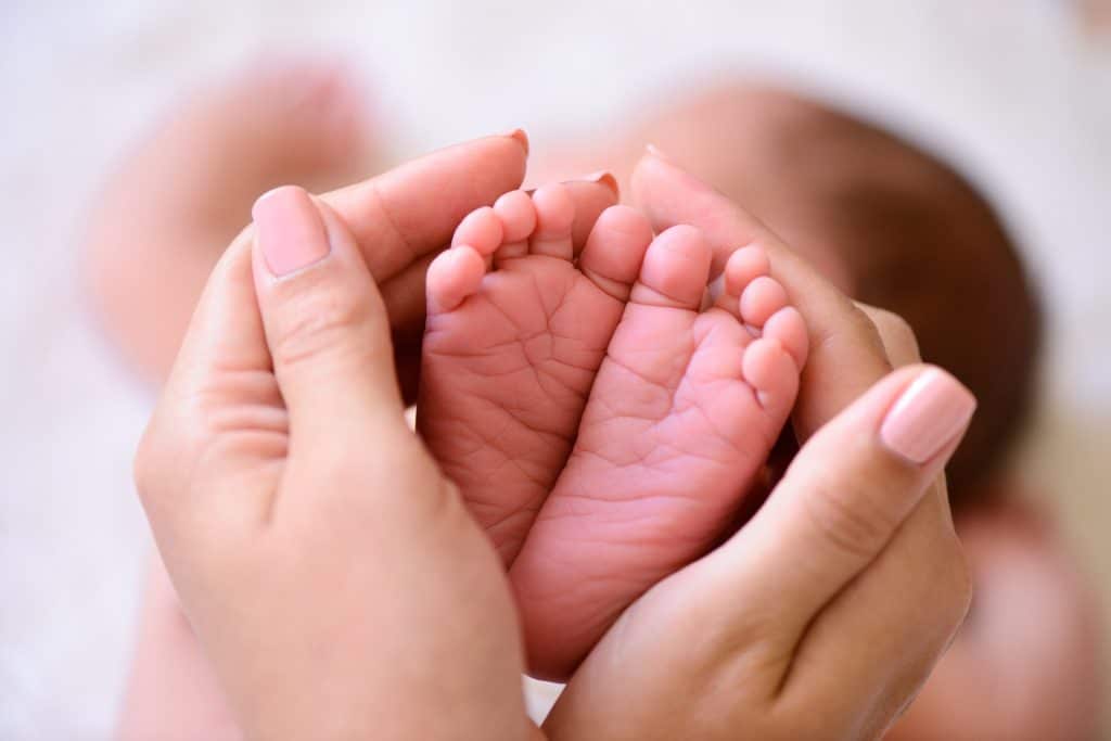 Newborn baby feet in someone's hands