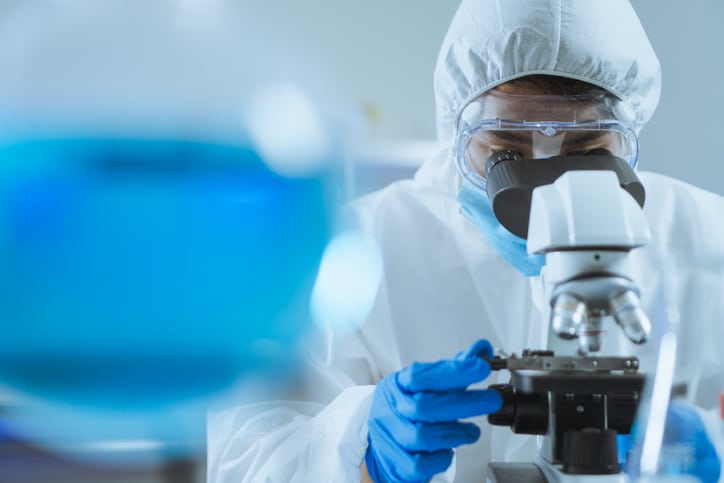 Laboratory professional looking through a microscope