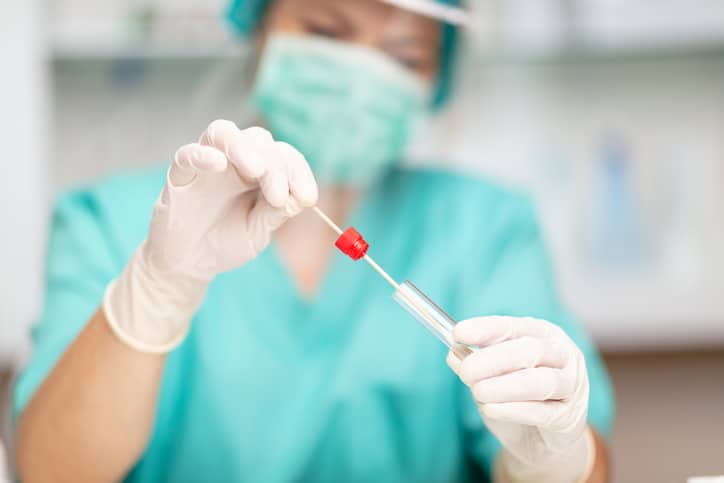 A medical professional preparing a nose swab