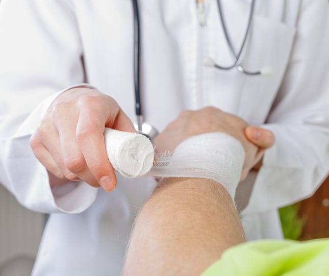 Medical professional wrapping someone's wrist in gauze