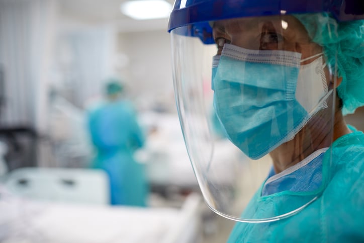 Medical professional in a mask, scrubs, face shield