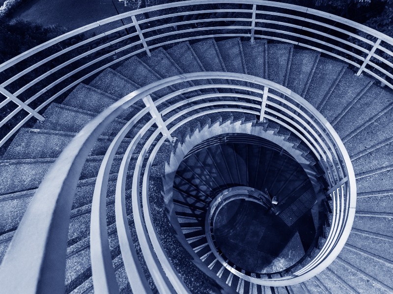 Night scene of spiral Staircase in monochrome used to explain the sensation of vertigo