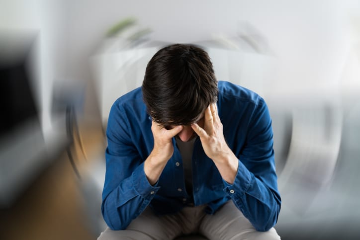 Man holding his forehead with his hands in a haze