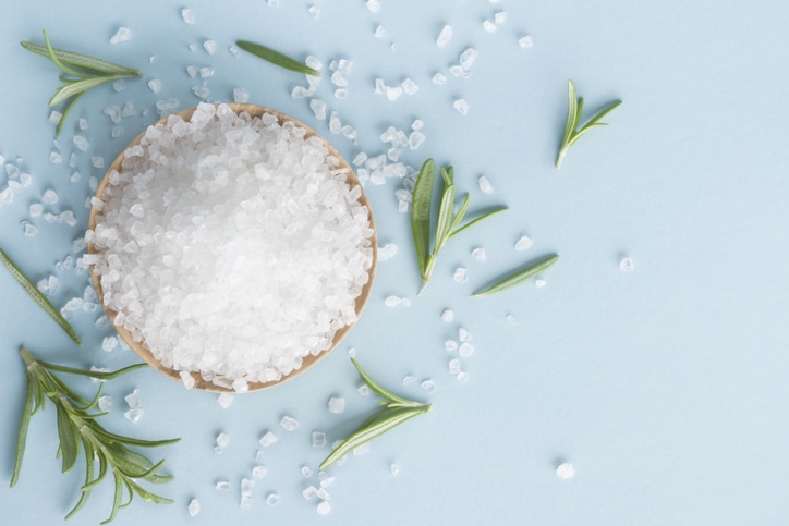 Coarse salt in a bowl surrounded by rosemary sprigs