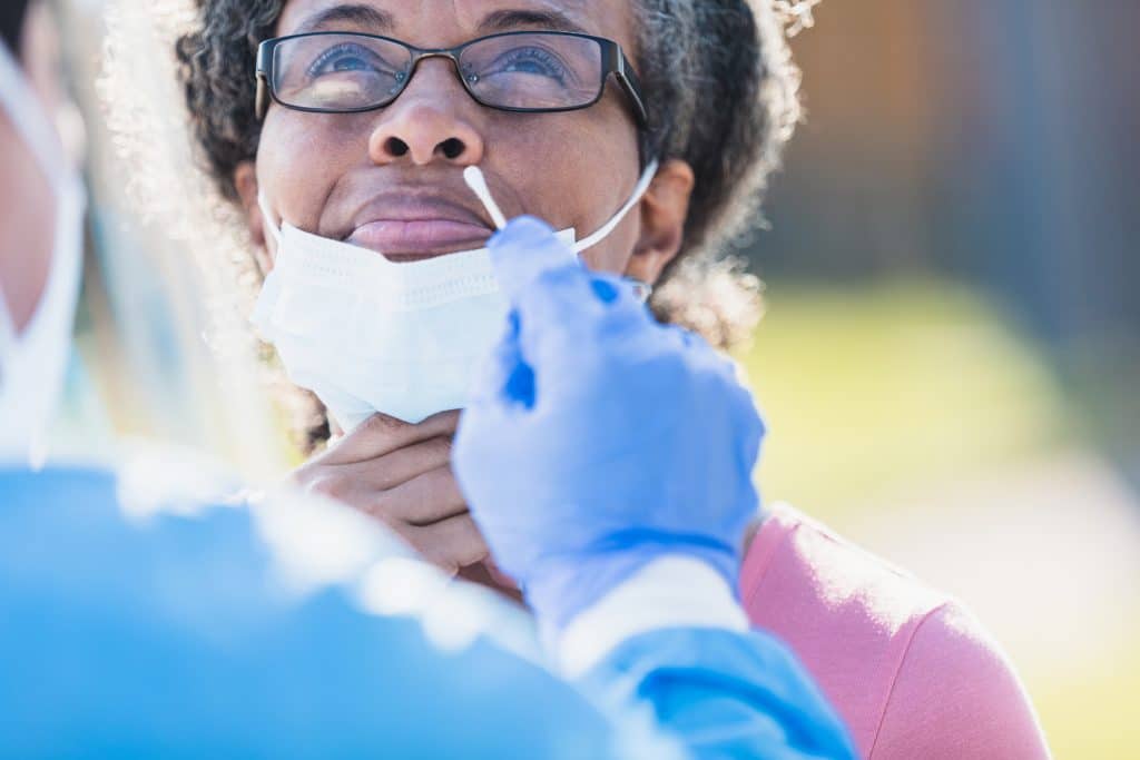 A woman looks up and forward as she receives a COVID-19 swap test