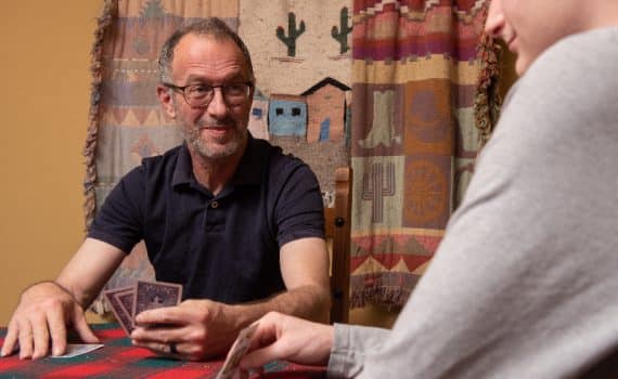 Roger Holcomb holding a cards and smiling after his widow maker heart attack survival