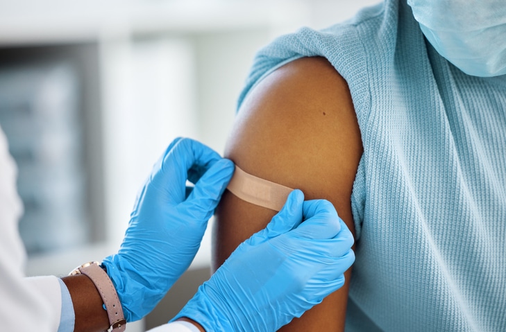 A medical provider placing a bandage on someone's arm