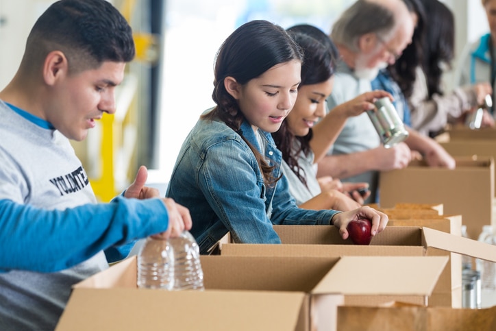 A group of people in a row helping pack up care packages