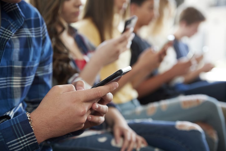 A group of people using and looking at their smartphones