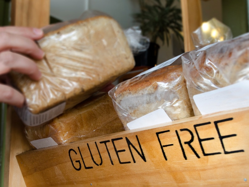 A bread box with loaves of bread inside with the words "Gluten Free" written on the box