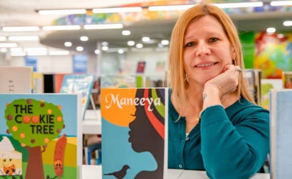 Kim Soesbee photographed in front of a few books standing upright