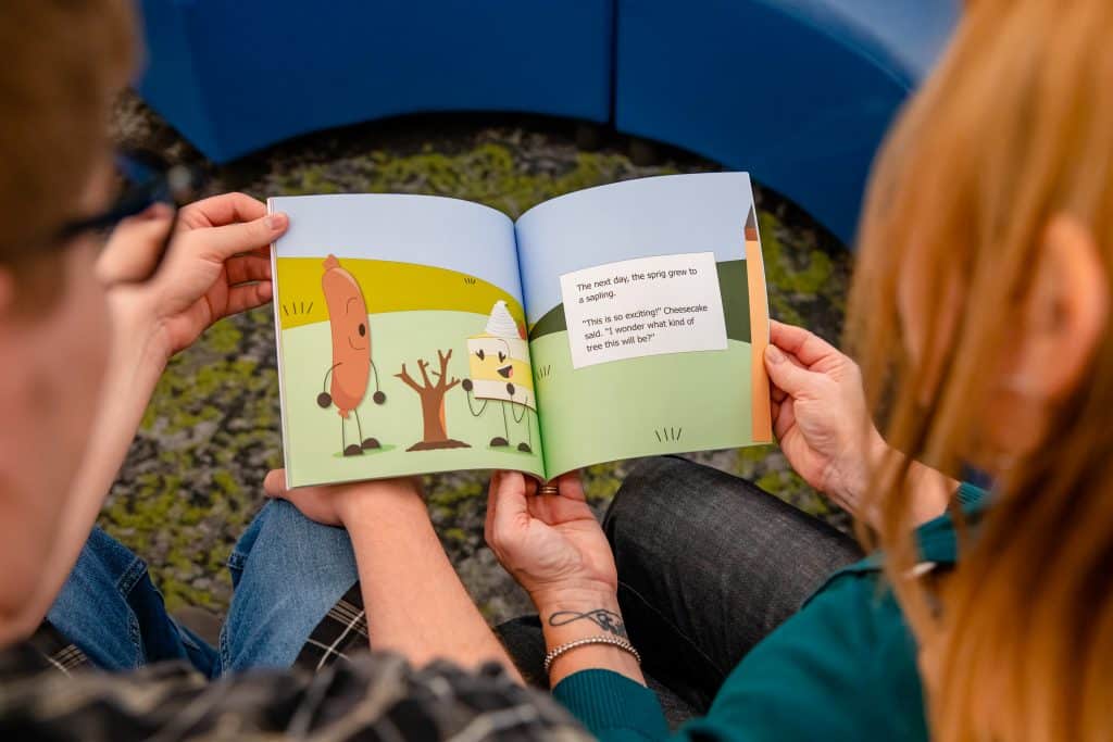 Kim Soesbee and her son Cooper holding a picture book and looking down at its pages