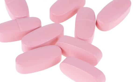 A collection of pink pills, used to explain Paxlovid