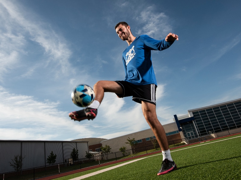 Zach Thibodeau kicking a soccer ball, photographed after his treatment for lymphoma
