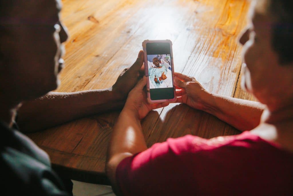 Waco police detective Dennis Taylor and his wife Jena photographed while both holding a smartphone with a photo of Dennis in recovery