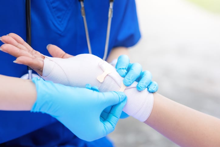 A medical provider stabilizing someone's wrist after an injury like a sprain