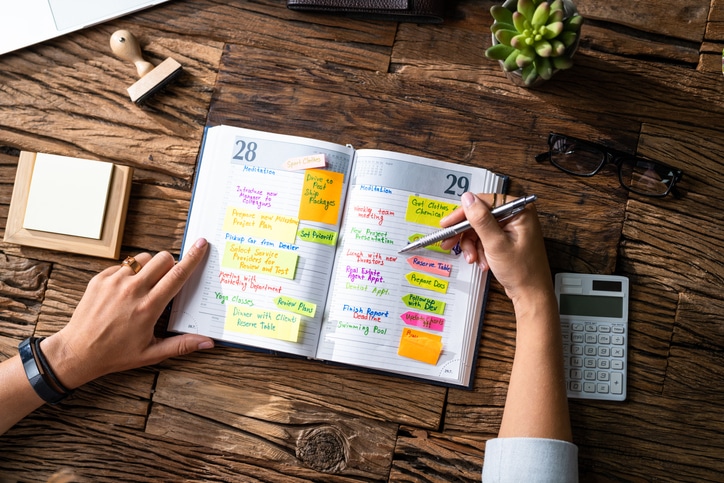 Stock image of a filled in day planner calendar with varied colors used for writing, used to explain time management techniques