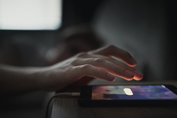 A hand hovering over a smartphone