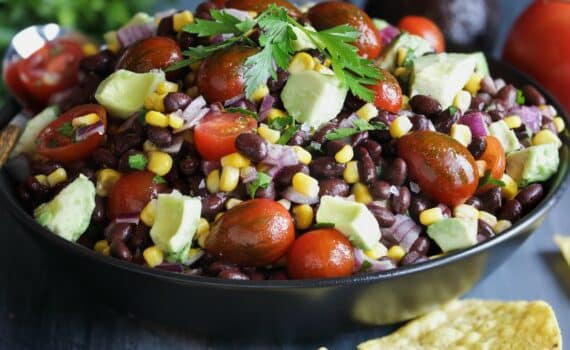 A photo of a healthy black bean, avocado, and tomato salad, used to explain the benefits of the DASH diet