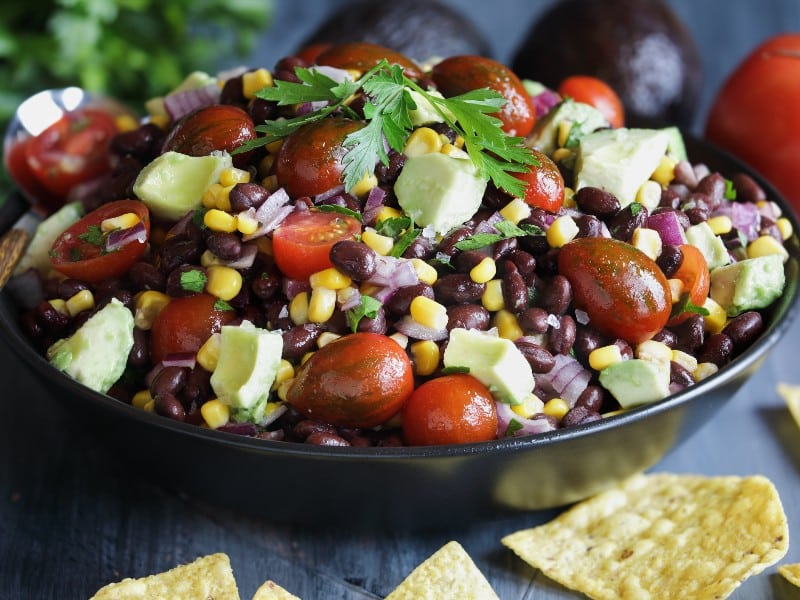 A photo of a healthy black bean, avocado, and tomato salad, used to explain the benefits of the DASH diet
