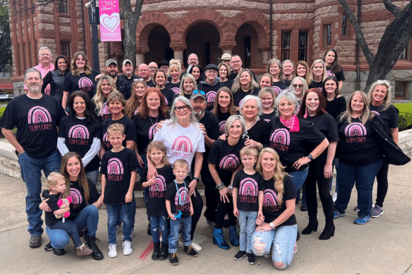 Judge Cindy Ermatinger photographed with a large group of people consisting of family and friends who made matching T-shirts for Cindy and her fight with cancer.