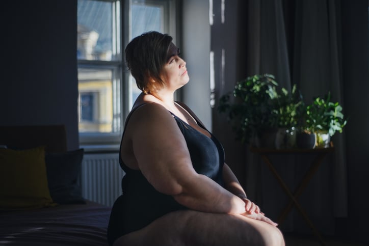 Photo of a woman looking up and off camera in dark natural lighting