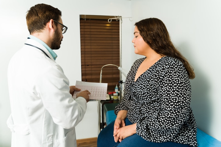 Woman looking at a medical chart that a medical provider in front of her is pointing to