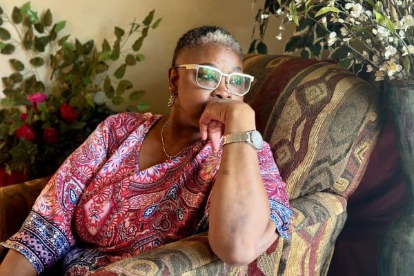 Dallas County correctional officer Wanda Grigsby wearing a colorful blouse and sitting in an armchair.