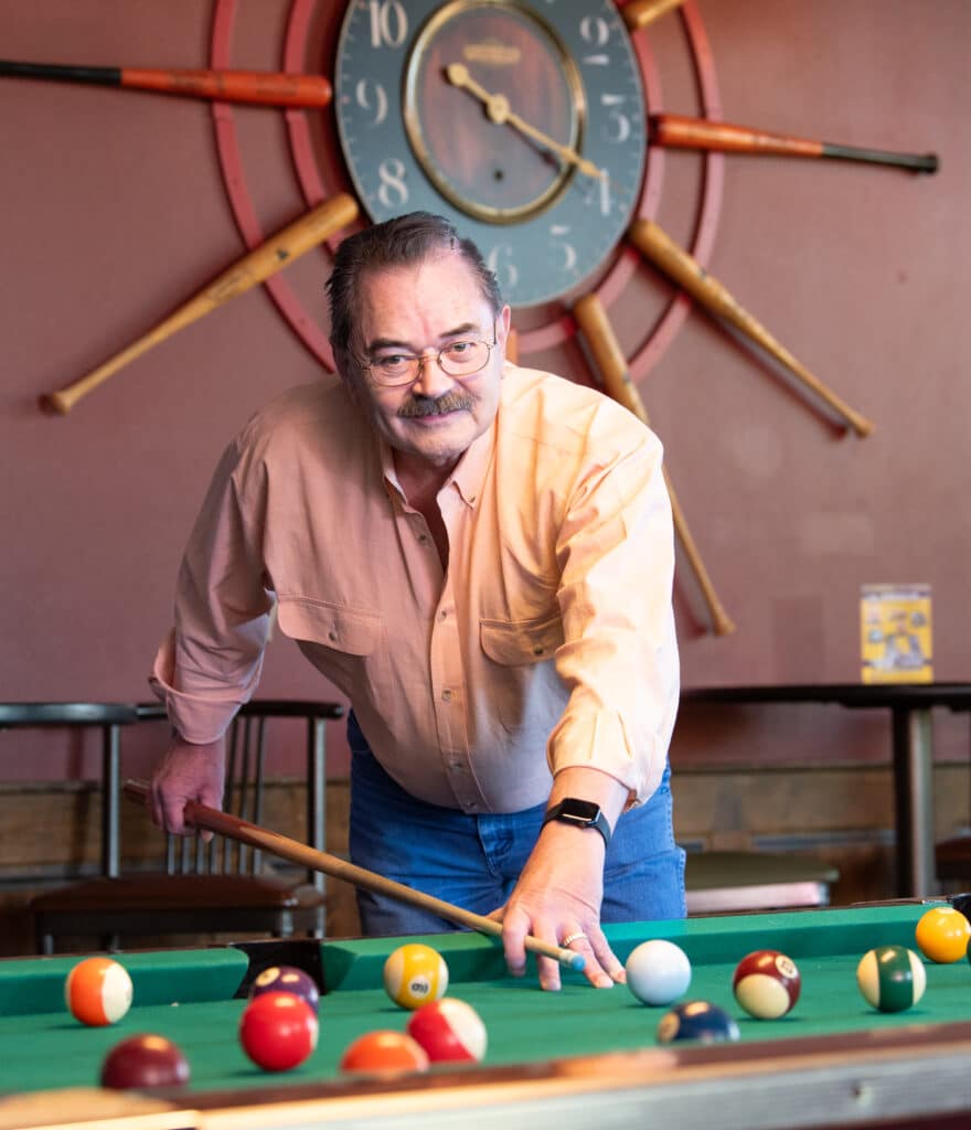 A man named Jack Crain photographed while playing pool