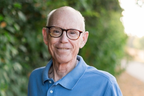 An older man named Gary Reynolds smiling, photographed in natural light